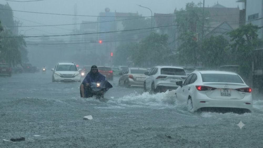 Mưa lớn gây ngập lụt diện rộng tại TP Vinh, Nghệ An; các xe ô tô, xe máy chật vật lội nước di chuyển trên đường phố ngập sâu.